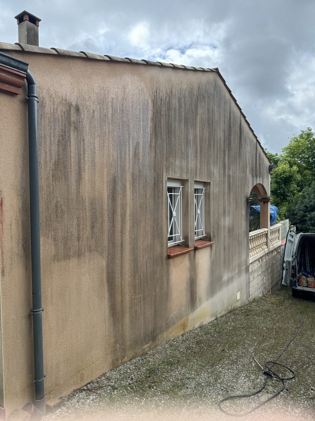 Façade encrassée par les coulures et les mousses avant nettoyage à Pompertuzat