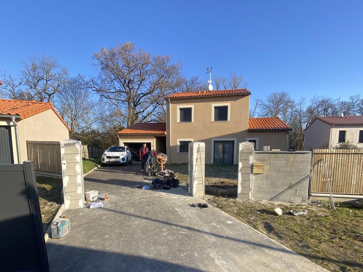 Piliers et mur en parpaings bruts avant la pose du portail à Merville