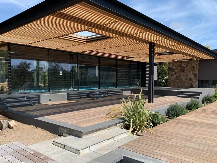 Terrasse en bois exotique et pergola à claire-voie réalisées par Entreprise Felicioni devant une villa contemporaine