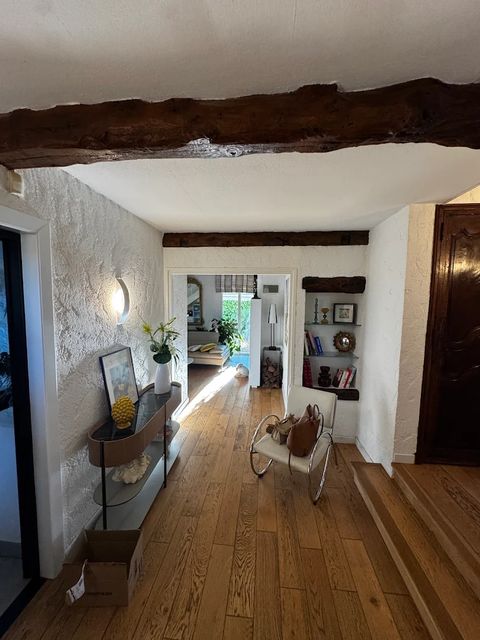 Séjour de villa rénové avec poutres en bois apparentes et parquet chêne massif